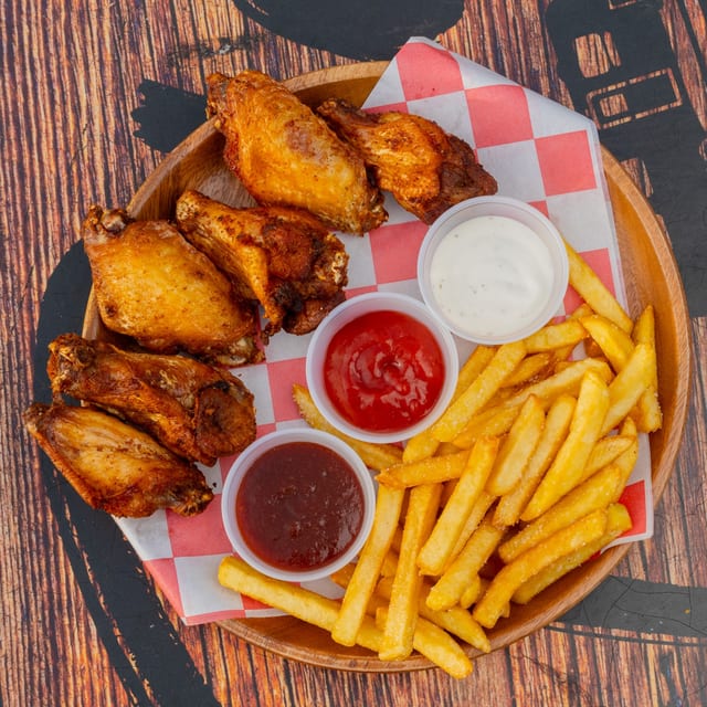 Alitas con papas fritas.